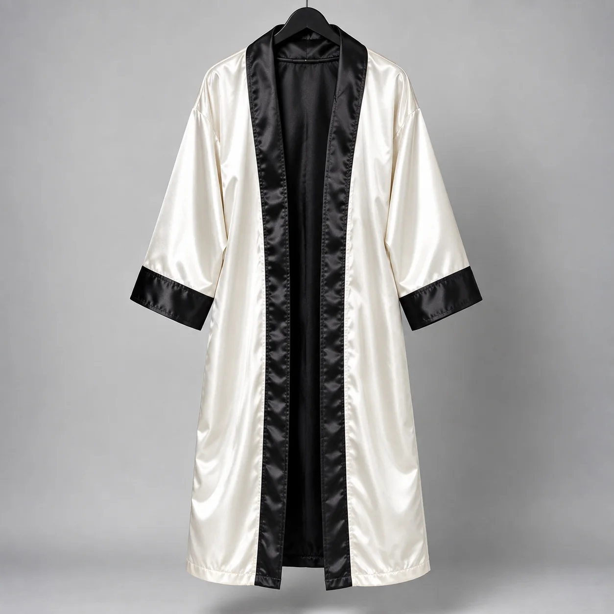 White boxing robe with black trim hanging in studio